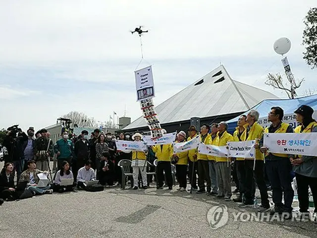 ビラ散布のパフォーマンスを行う「戦後拉北者被害家族連合会」の関係者＝２３日、坡州（聯合ニュース）