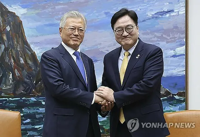 禹元植（ウ・ウォンシク）国会議長（右）と握手を交わす文氏（国会写真記者団）＝２５日、ソウル（聯合ニュース）