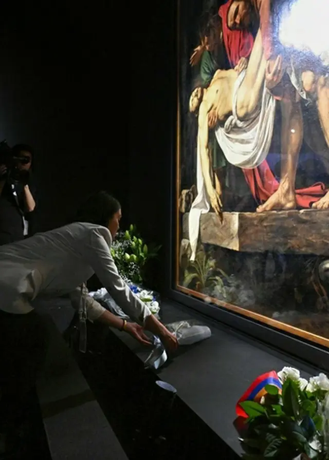 バチカン展示室に飾られているイタリアの画家、カラバッジョが描いた「キリストの埋葬」の前に献花する追悼客＝（共同＝聯合ニュース）