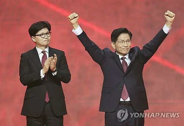 韓国保守政党「国民の力」は３日に党大会を開き、大統領選（６月３日投開票）の党公認候補に金文洙（キム・ムンス）前雇用労働部長官（７３）を選出した。最終予備選を戦った韓東勲（ハン・ドンフン）前代表（左）の横で喜ぶ金氏＝（聯合ニュース）