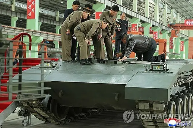 戦車の上から中をのぞき込む金正恩氏（右端）＝（朝鮮中央通信＝聯合ニュース）＝（聯合ニュース）≪転載・転用禁止≫