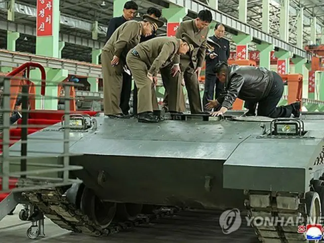 戦車の上から中をのぞき込む金正恩氏（右端）＝（朝鮮中央通信＝聯合ニュース）＝（聯合ニュース）≪転載・転用禁止≫