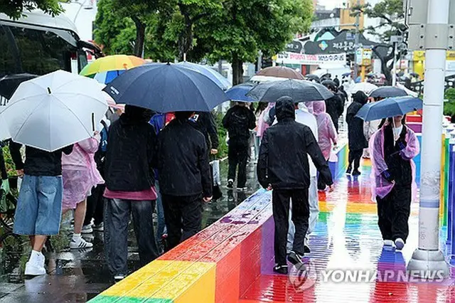 雨が降る済州市内を歩く修学旅行生ら＝９日、済州（聯合ニュース）