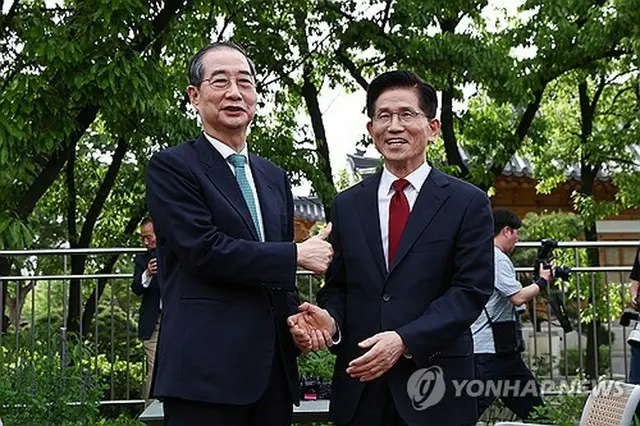 ８日に行った会合で握手する韓氏（左）と金氏（共同取材）＝（聯合ニュース）