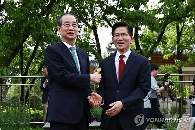 握手する韓氏（左）と金氏（資料写真）＝（聯合ニュース）
