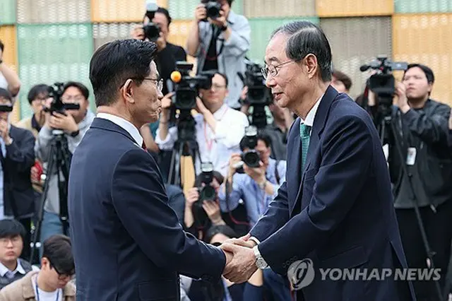 金文洙氏（左）と韓悳洙氏＝８日、ソウル（聯合ニュース）