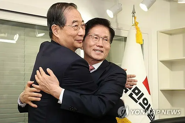 「国民の力」本部で行った会談で抱擁する金文洙氏（右）と韓悳洙氏＝１１日、ソウル（聯合ニュース）