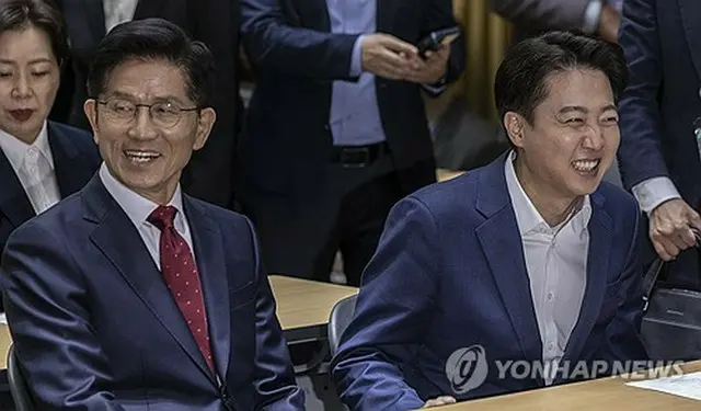ソウル市庁舎で開かれた討論会に出席した金文洙氏（左）と李俊錫氏＝１９日、ソウル（聯合ニュース）
