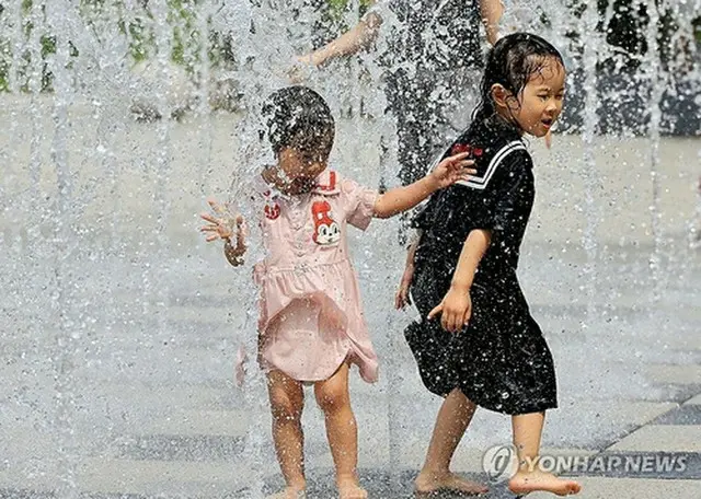 噴水で水遊びする子どもたち＝２１日、ソウル（聯合ニュース）