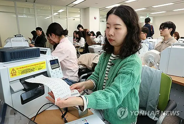 韓国大統領選の期日前投票を控え、投票用紙交付機の使い方を確認する公務員（資料写真）＝（聯合ニュース）