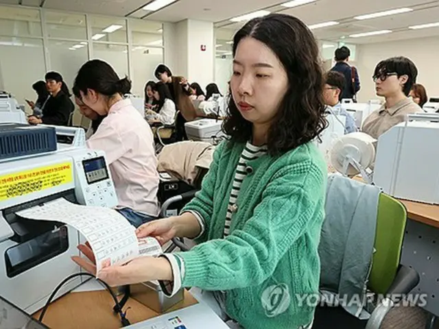 韓国大統領選の期日前投票を控え、投票用紙交付機の使い方を確認する公務員（資料写真）＝（聯合ニュース）
