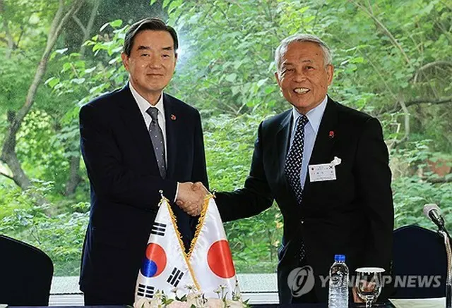 握手する金氏（左）と麻生氏＝２８日、ソウル（聯合ニュース）