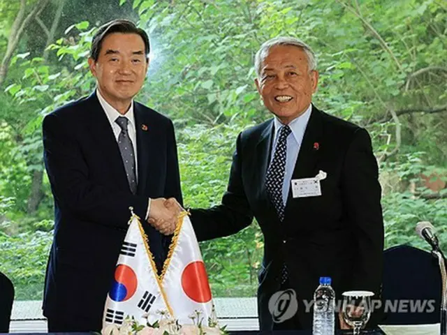 握手する金氏（左）と麻生氏＝２８日、ソウル（聯合ニュース）