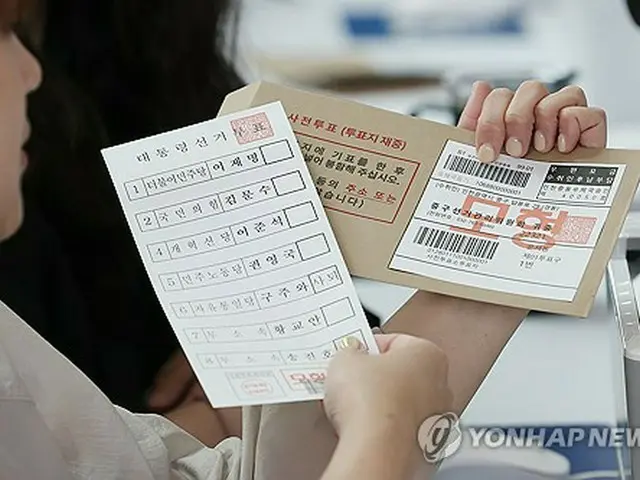 仁川空港の期日前投票所で投票用紙と不在者投票のための転送用封筒をみせる関係者＝（聯合ニュース）