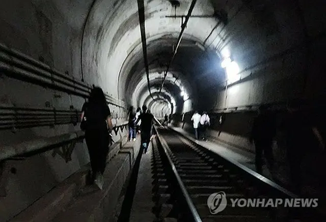 トンネルを歩いて避難する乗客（読者提供）＝（聯合ニュース）≪転載・転用禁止≫