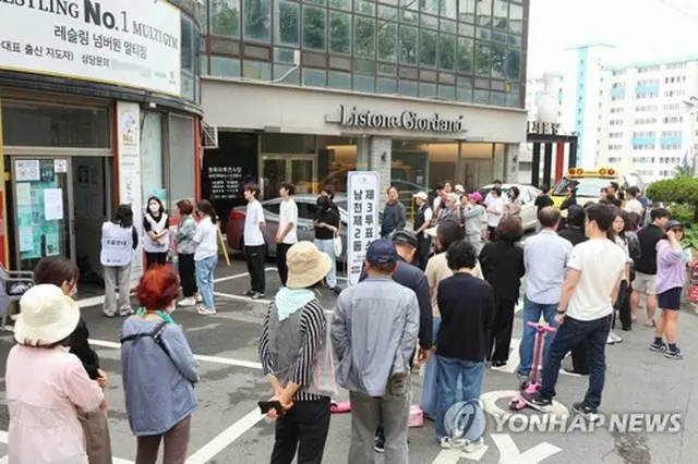 韓国南部、釜山市内の投票所前には長い列ができている＝３日、釜山（聯合ニュース）