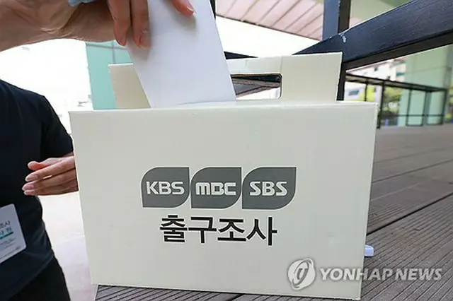 韓国大統領選の投票日の３日、ソウル市内の投票所前で地上波テレビ局３社（ＫＢＳ、ＭＢＣ、ＳＢＳ）による出口調査を行う放送局の調査員。投票は同日午後８時に締め切られ、即日開票される＝（聯合ニュース）