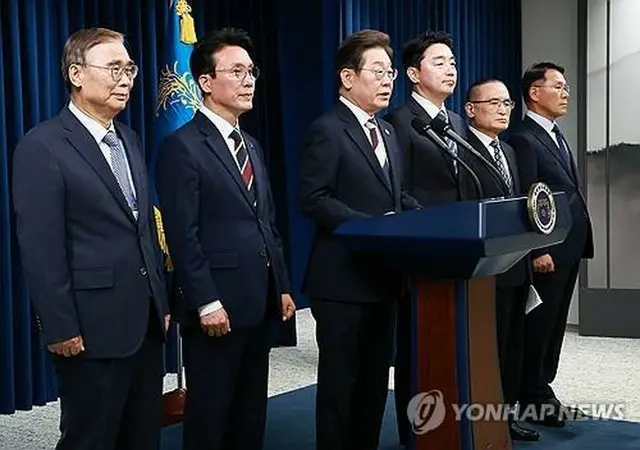 大統領室で人事を発表する李大統領（左から３人目）＝４日、ソウル（聯合ニュース）