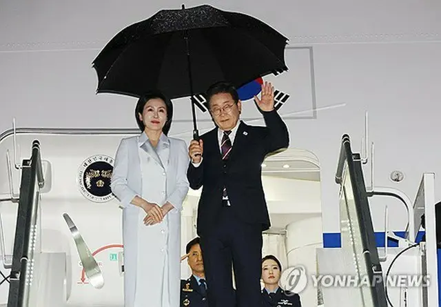 カルガリー国際空港で専用機に乗り込む李大統領夫妻＝１７日、カルガリー（聯合ニュース）