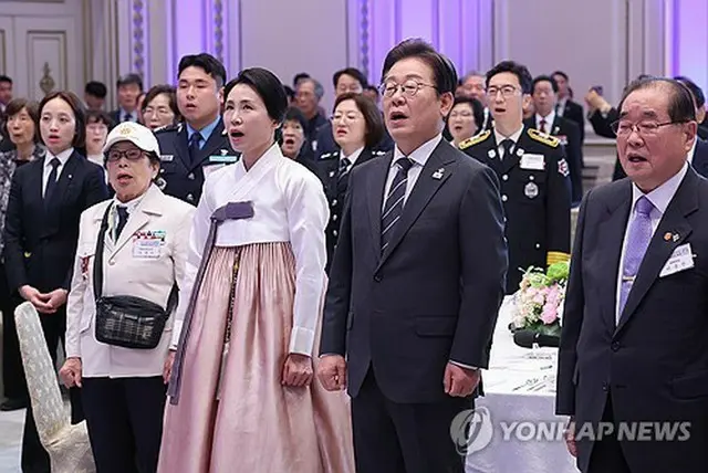 国歌「愛国歌」を歌う李大統領夫妻と出席者＝２７日、ソウル（聯合ニュース）
