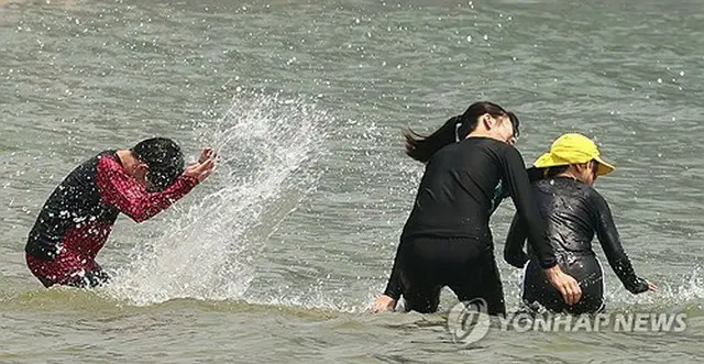 釜山の海水浴場で水遊びを楽しむ人々＝（聯合ニュース）