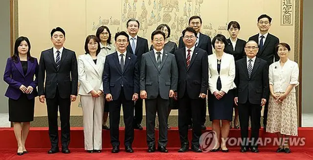 任命状の授与式を終えて出席者と記念撮影を行う李大統領（中央、大統領室通信写真記者団）。左隣は金民錫首相＝４日、ソウル（聯合ニュース）