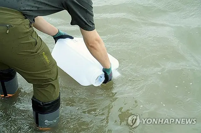 江華島で試料を採取する韓国原子力安全技術院の関係者（同委員会提供）＝（聯合ニュース）≪転載・転用禁止≫