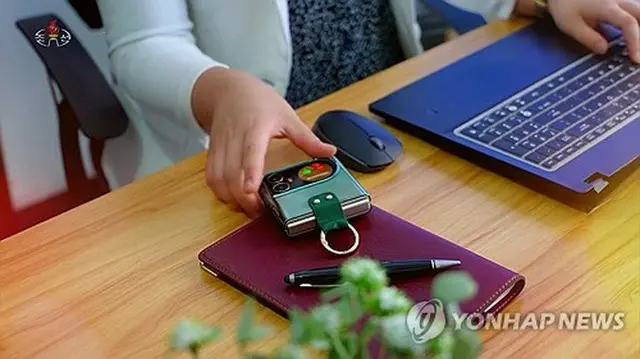 ２４年６月に朝鮮中央テレビが公開した北朝鮮の折り畳みスマホ（朝鮮中央テレビより）＝（聯合ニュース）≪転載・転用禁止≫