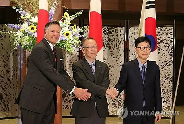 握手を交わす韓国外交部の朴潤柱第１次官（右）と米国務省のクリストファー・ランドー副長官（左）、日本外務省の船越健裕次官＝１８日、東京（聯合ニュース）