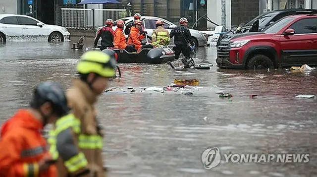 大邱市内の冠水した道路をボートで移動する救助隊＝（聯合ニュース）