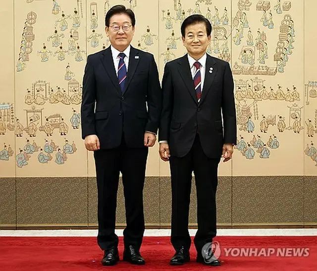 大統領室で記念撮影する李大統領（左）と鄭東泳・統一部長官＝２８日、ソウル（聯合ニュース）