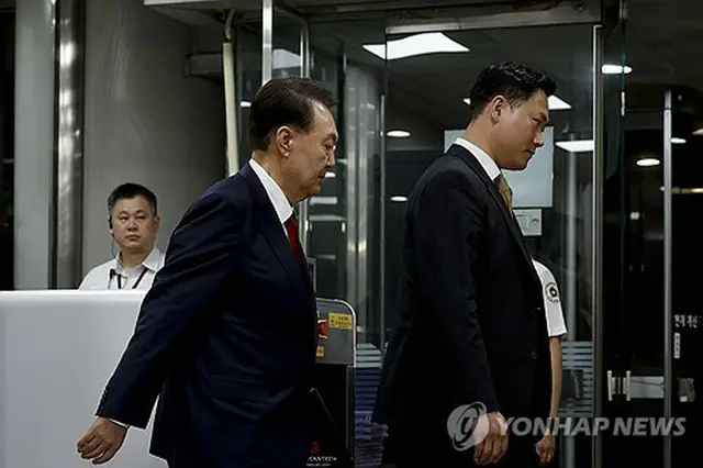 ７月９日、自身の逮捕状の発付可否を決める令状審査を受け、ソウル中央地裁を出る尹前大統領（左）＝（聯合ニュース）
