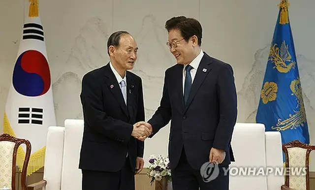 あいさつを交わす李大統領（右）と菅元首相＝３０日、ソウル（聯合ニュース）