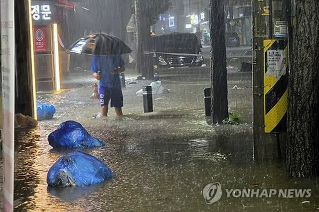 ３日夜、南西部・光州市内で冠水した道路を歩く市民（読者提供）＝（聯合ニュース）≪転載・転用禁止≫