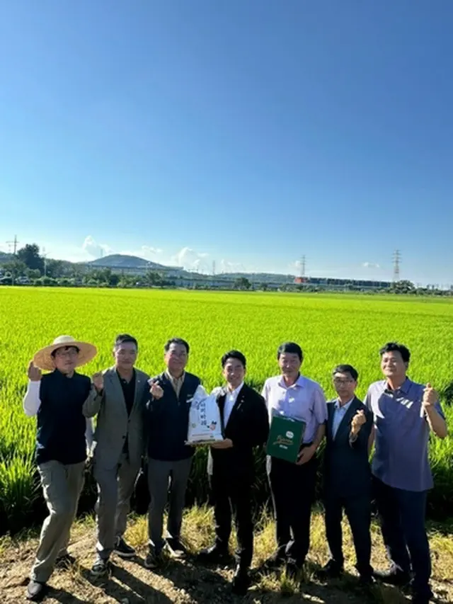 坡州市の田んぼの前で記念撮影する小泉氏（中央）と関係者（読者提供）＝（聯合ニュース）≪転載・転用禁止≫