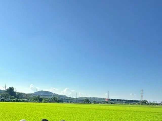 坡州市の田んぼの前で記念撮影する小泉氏（中央）と関係者（読者提供）＝（聯合ニュース）≪転載・転用禁止≫