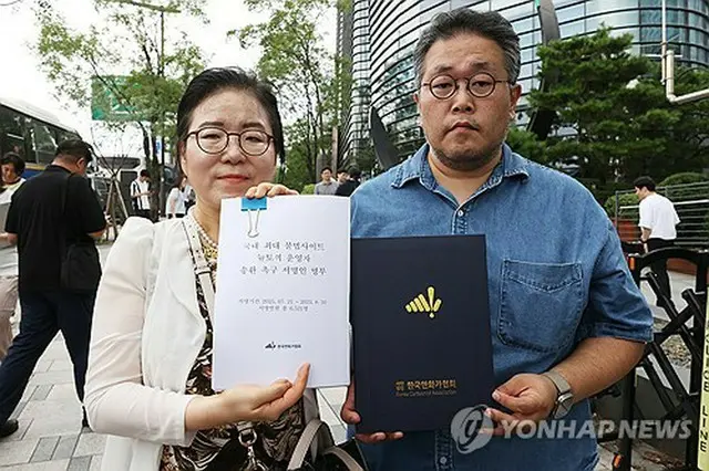 集会に参加した申一淑（シン・イルスク）韓国漫画家協会長（左）と権赫周（クォン・ヒョクジュ）韓国ウェブトゥーン作家協会長＝１１日、ソウル（聯合ニュース）