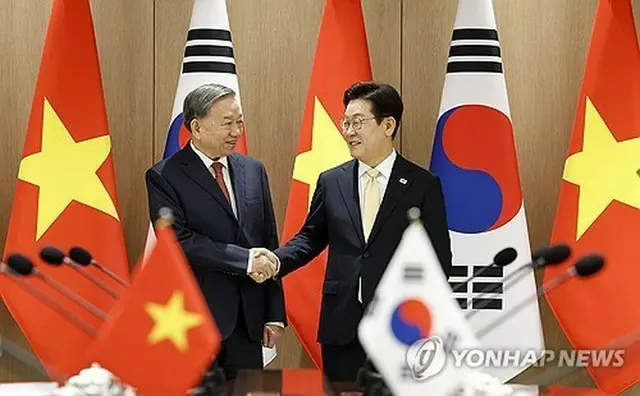 首脳会談を前に握手する李在明大統領（右）とトー・ラム共産党書記長（大統領室通信写真記者団）＝１１日、ソウル（聯合ニュース）
