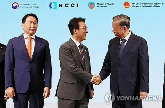 ビジネスフォーラムで握手を交わす韓国の金民錫首相（左）とベトナムのトー・ラム共産党書記長＝１２日、ソウル（聯合ニュース）