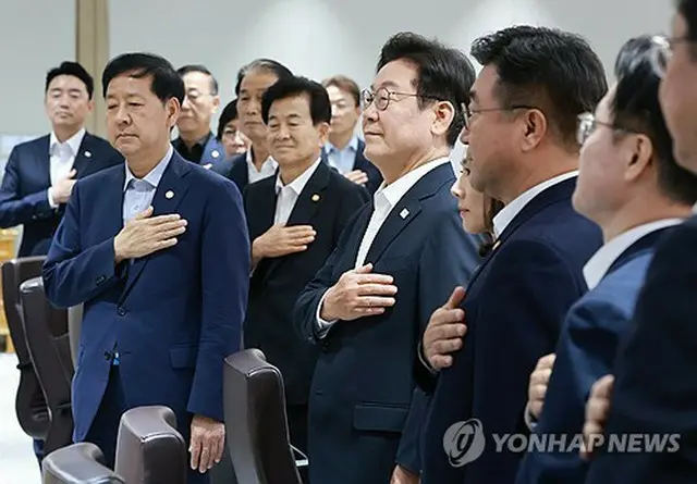 臨時閣議で国旗に敬礼する李在明大統領（中央）＝１１日、ソウル（聯合ニュース）