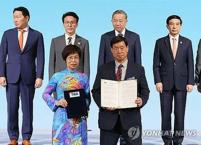 聯合ニュースの黄大一（ファン・デイル）社長（手前右）とＶＮＡのブー・ビエット・チャン社長（同左）＝１２日、ソウル（聯合ニュース）
