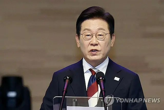 「統合」を象徴する青と赤、白色のネクタイを着用した李在明大統領＝１５日、ソウル（聯合ニュース）