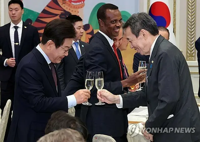 水嶋大使（右）とグラスを合わせる李大統領＝１５日、ソウル（聯合ニュース）