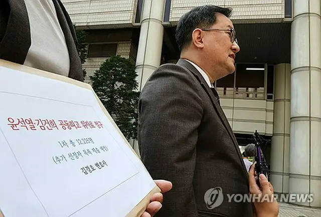 訴状提出に先立ち、ソウル中央地裁の前で取材に応じる代理人の弁護士＝１８日、ソウル（聯合ニュース）