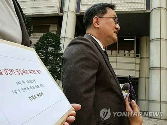 訴状提出に先立ち、ソウル中央地裁の前で取材に応じる代理人の弁護士＝１８日、ソウル（聯合ニュース）