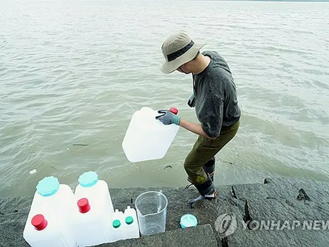韓国北西部の江華島で試料を採取する韓国原子力安全技術院の関係者（原子力安全委員会提供）＝（聯合ニュース）≪転載・転用禁止≫
