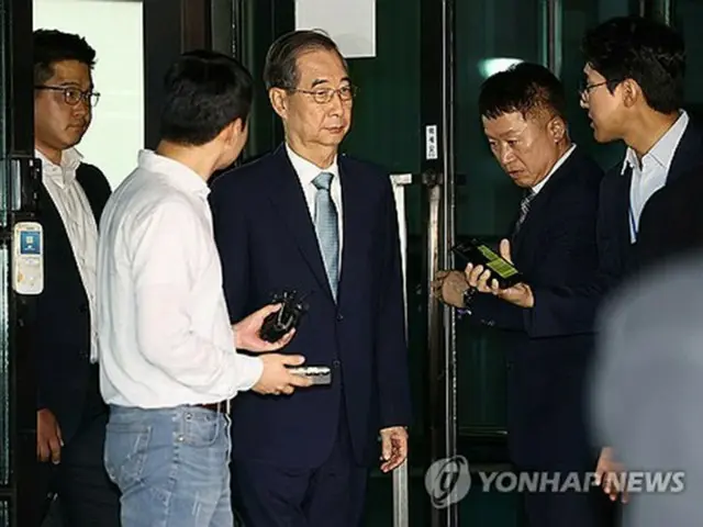 韓悳洙前首相（中央）が２０日未明、約１６時間に及ぶ特別検察官チームの取り調べを終え帰宅した。事務所が置かれているソウル高検を出る韓氏＝２０日、ソウル（聯合ニュース）