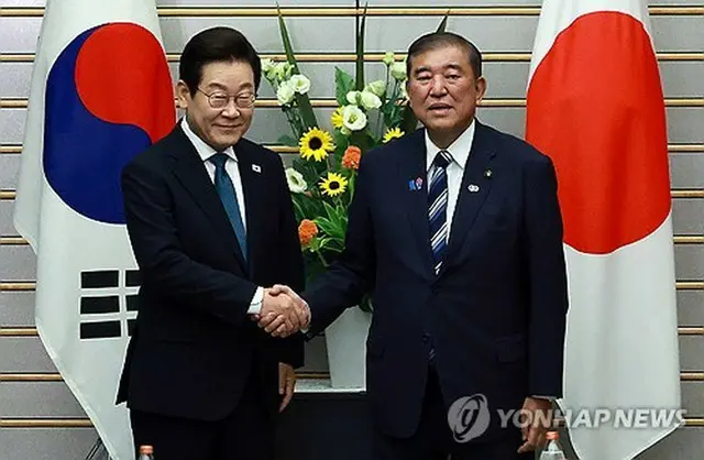首脳会談で握手を交わす李大統領（左）と石破首相＝２３日、東京（聯合ニュース）