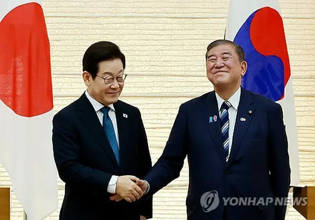 首脳会談後に行った共同記者発表で握手を交わす韓国の李大統領（左）と日本の石破首相＝２３日、東京（聯合ニュース）