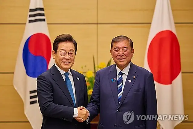 首脳会談で握手を交わす韓国の李大統領（左）と日本の石破首相＝２３日、東京（聯合ニュース）